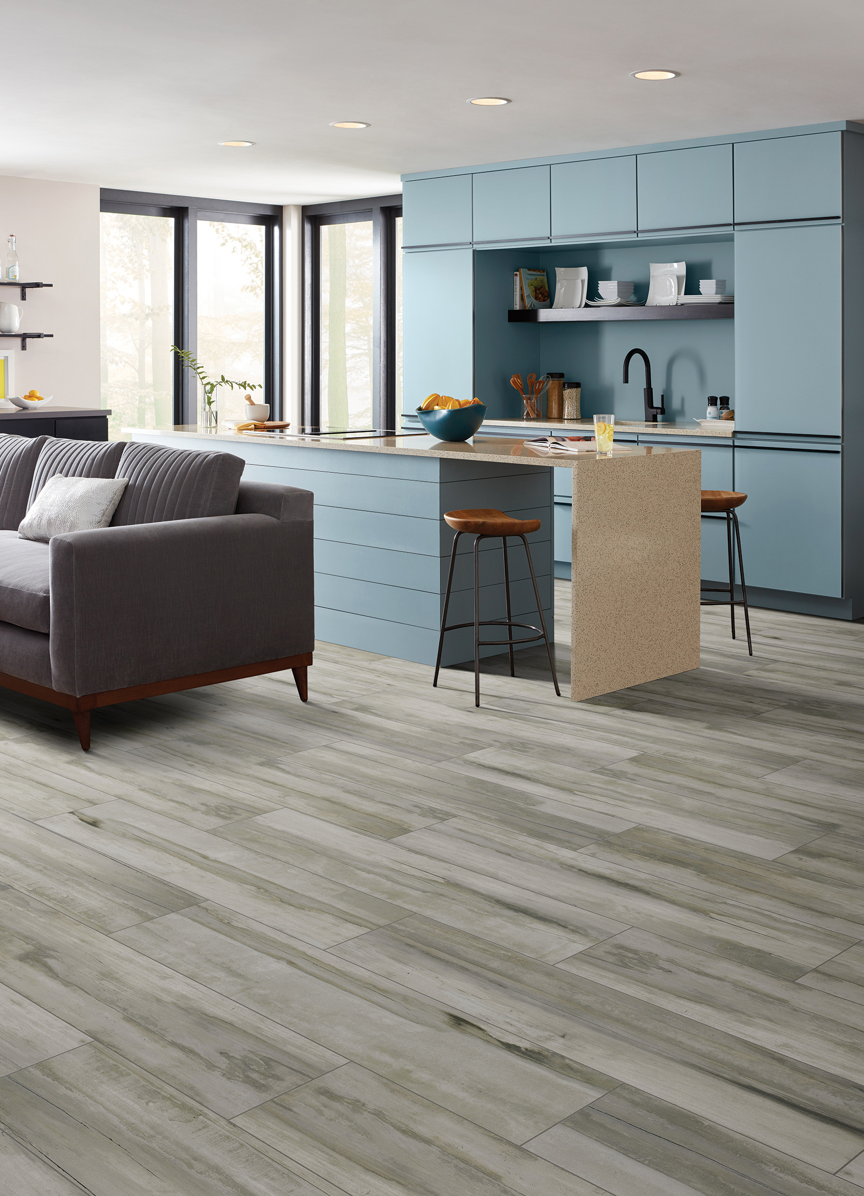 Arcadian Scene wood-look tile featuring baby blue kitchen cabinetry, island and couch in an open concept living/kitchen space